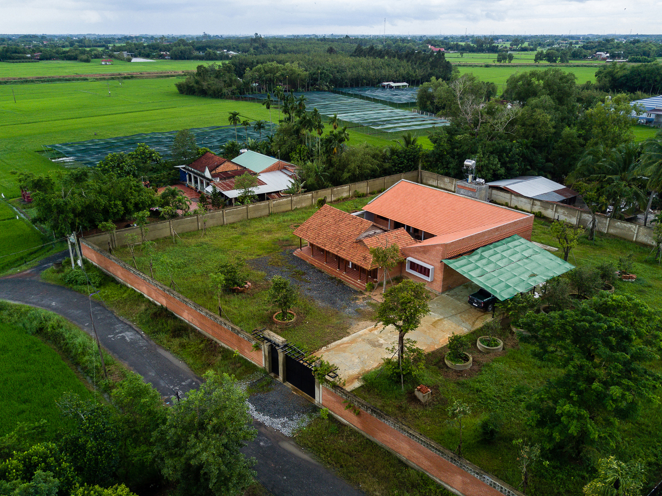 Nhà được xây dựng bằng gạch đỏ và có mái ngói kiểu Thái